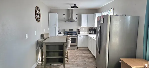 a kitchen with stainless steel appliances a refrigerator and a stove top oven