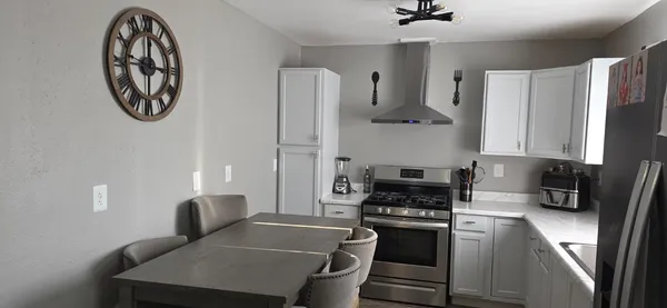 a kitchen with stainless steel appliances granite countertop a stove a refrigerator and a stove