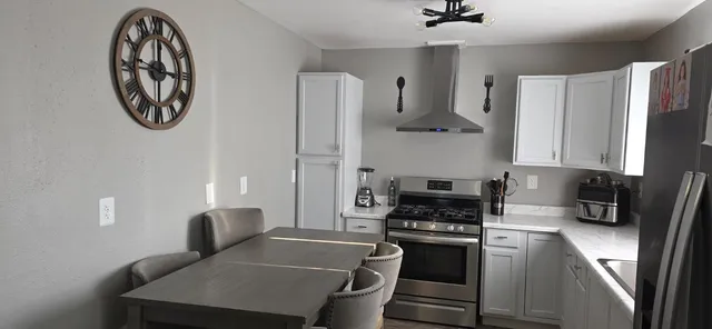 a kitchen with stainless steel appliances granite countertop a stove a refrigerator and a stove