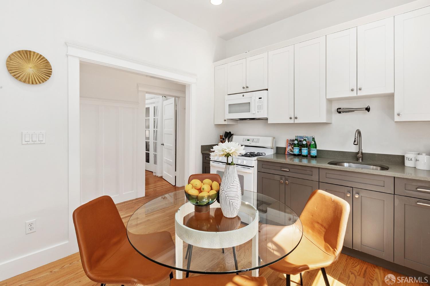 a kitchen with stainless steel appliances granite countertop a dining table and chairs