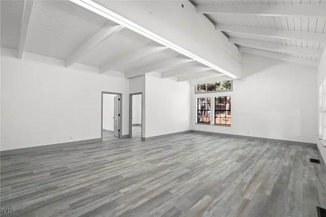 a view of a room with wooden floors and white walls