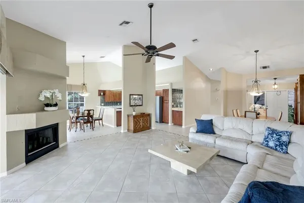 a living room with furniture a fireplace and a chandelier