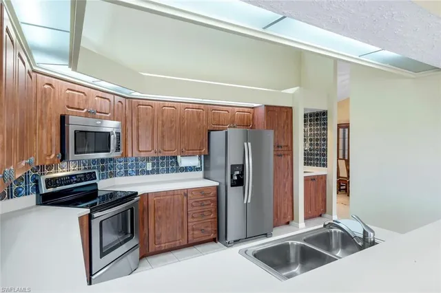 a kitchen with stainless steel appliances a refrigerator a stove a sink and dishwasher