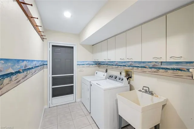 a utility room with cabinets washer and dryer