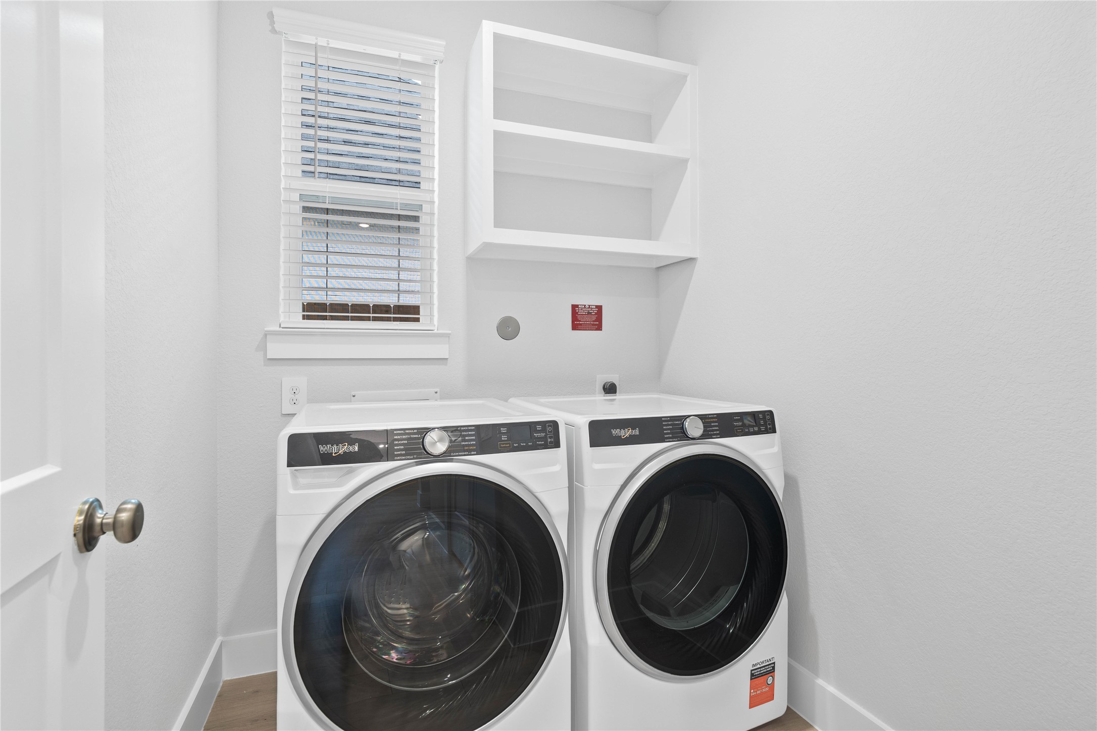 2035 Frst Strm Way Conroe, TX 77304 - Photo 13 of 45 Convenient utility space showcasing Whirlpool front-load washer and dryer appliance set with shelving above to store your laundry needs.