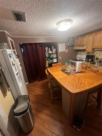 a kitchen with a table chairs and a wooden floor