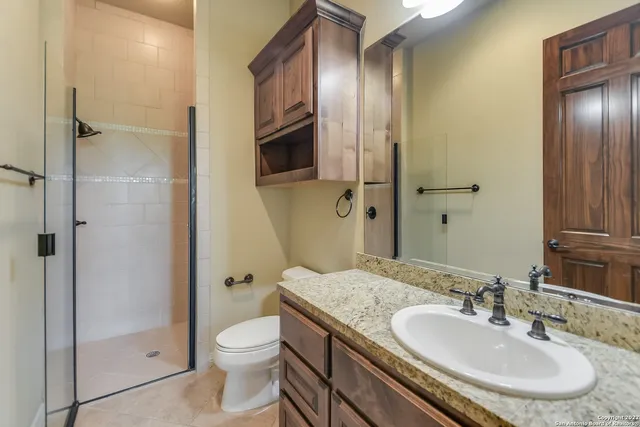 a bathroom with a granite countertop sink toilet and shower