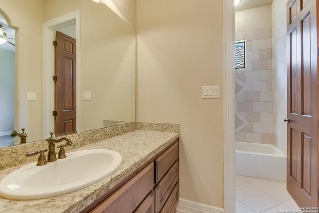 a bathroom with a granite countertop sink and a mirror
