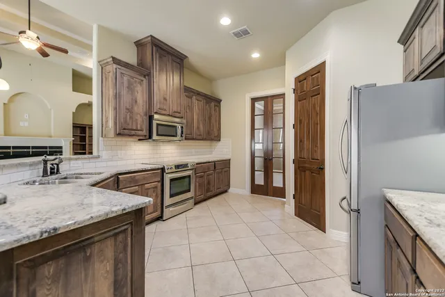 a kitchen with stainless steel appliances granite countertop a sink stove and refrigerator