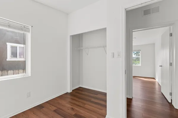 a view of an empty room with wooden floor