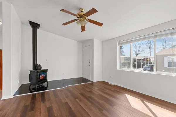 a view of empty room with wooden floor and fan