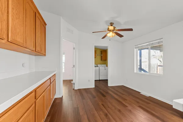a view of a kitchen with a sink and dishwasher with wooden floor