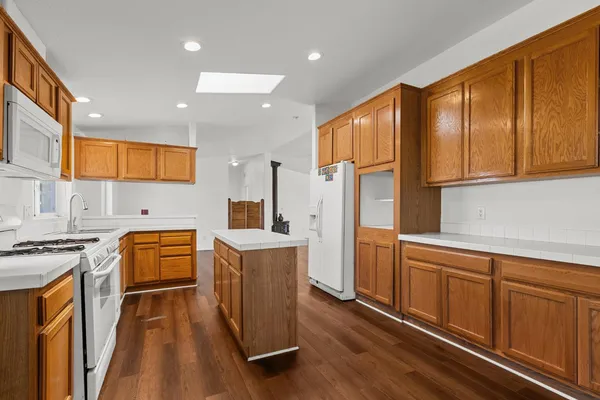 a kitchen with stainless steel appliances granite countertop a refrigerator a stove top oven a sink and dishwasher