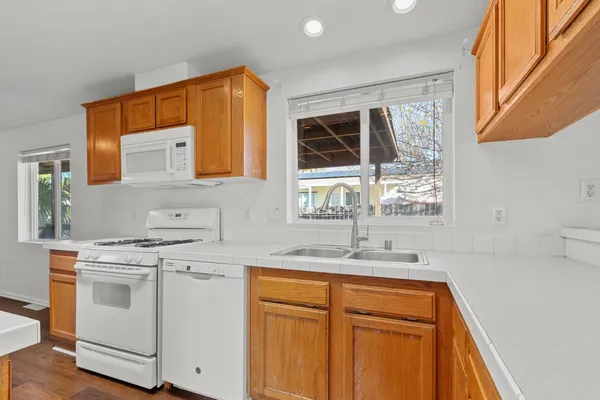 a kitchen with stainless steel appliances granite countertop a sink and wooden cabinets