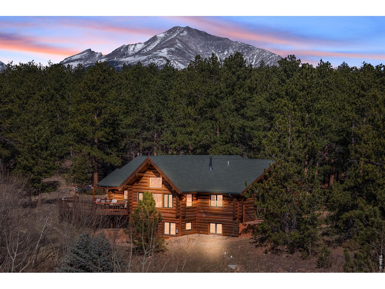 a front view of a house with a yard and mountain in the background