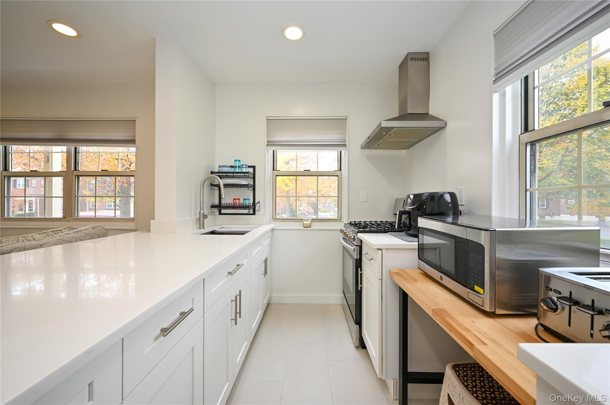 69-25 215th Street, Unit A Queens, NY 11364 - Photo 6 of 17 a kitchen with a stove a sink and a window
