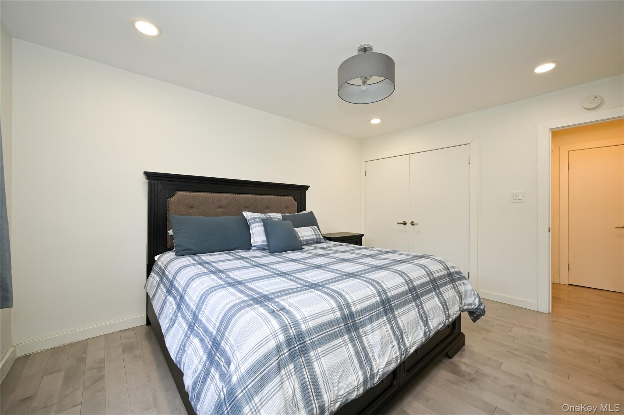 69-25 215th Street, Unit A Queens, NY 11364 - Photo 9 of 17 a bedroom with a bed and a chandelier