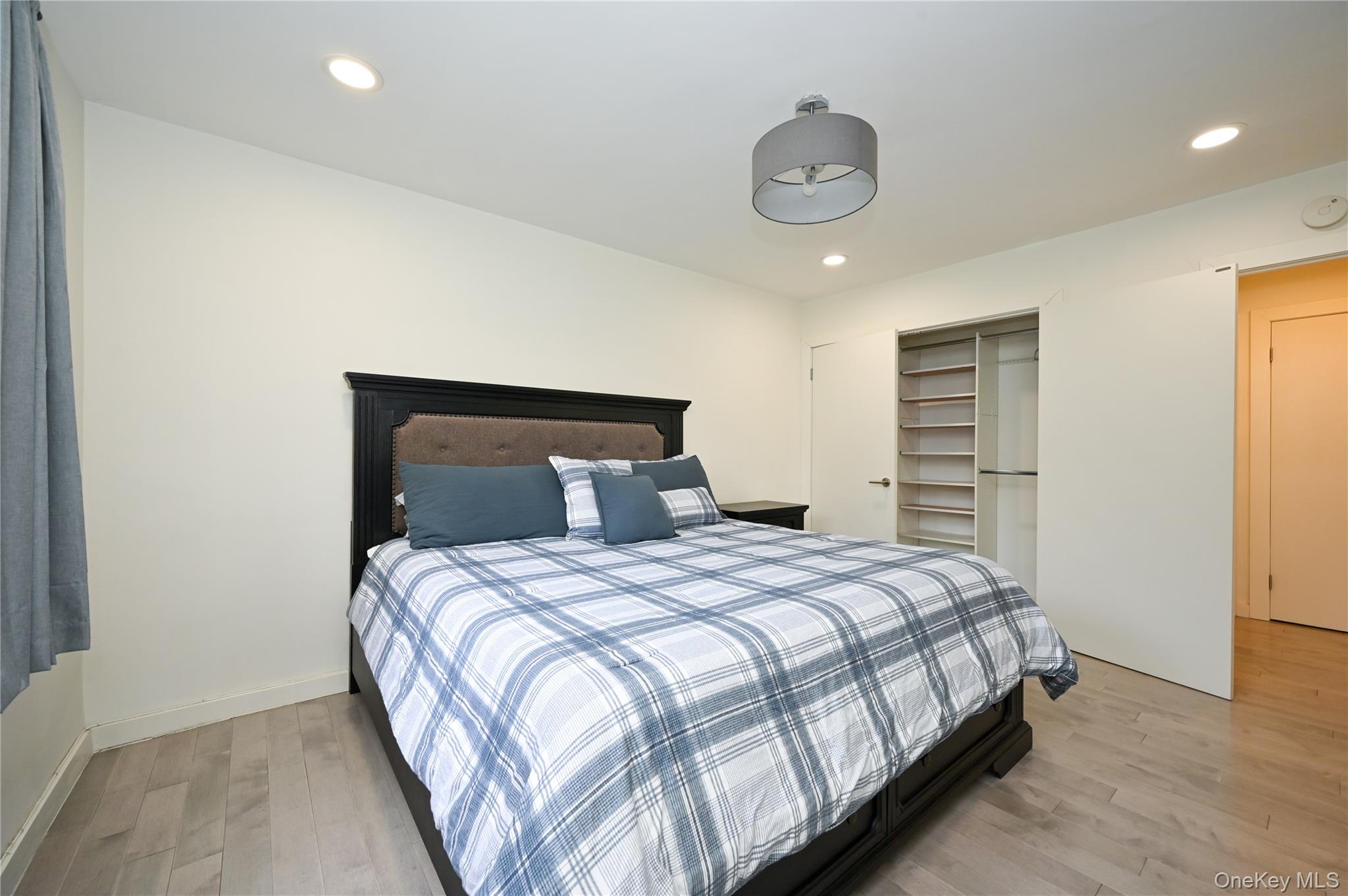 69-25 215th Street, Unit A Queens, NY 11364 - Photo 10 of 17 a bedroom with a bed and a chandelier