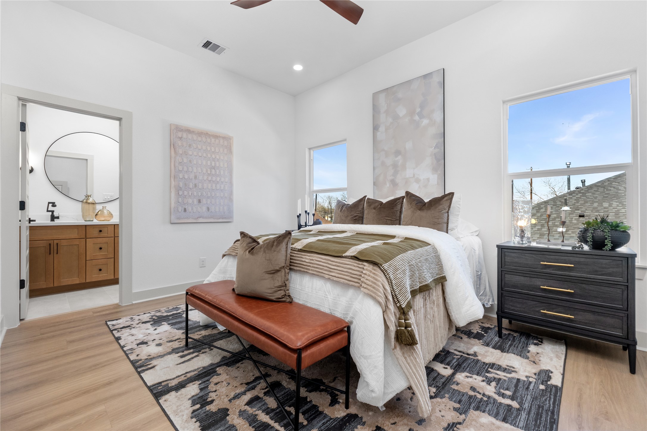 9819 Turnbow Street, Unit CD Houston, TX 77029 - Photo 16 of 32 a bedroom with a bed a mirror on dresser and a wooden floor