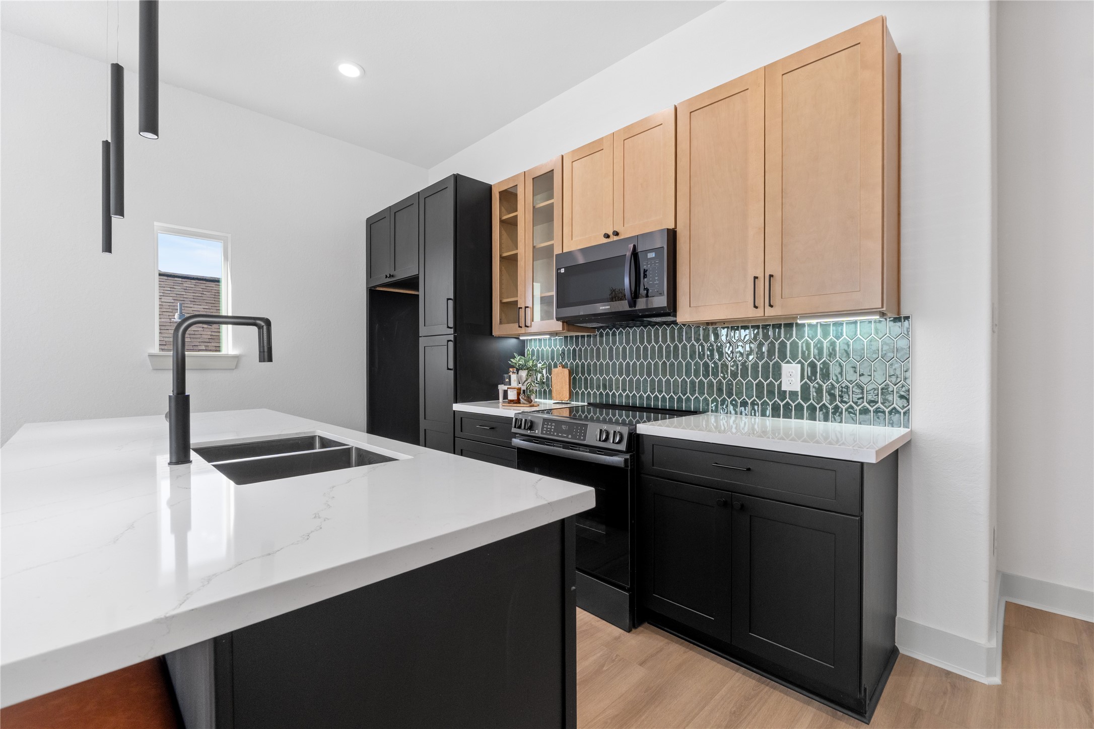 9819 Turnbow Street, Unit CD Houston, TX 77029 - Photo 9 of 32 a kitchen with a sink a stove and a microwave