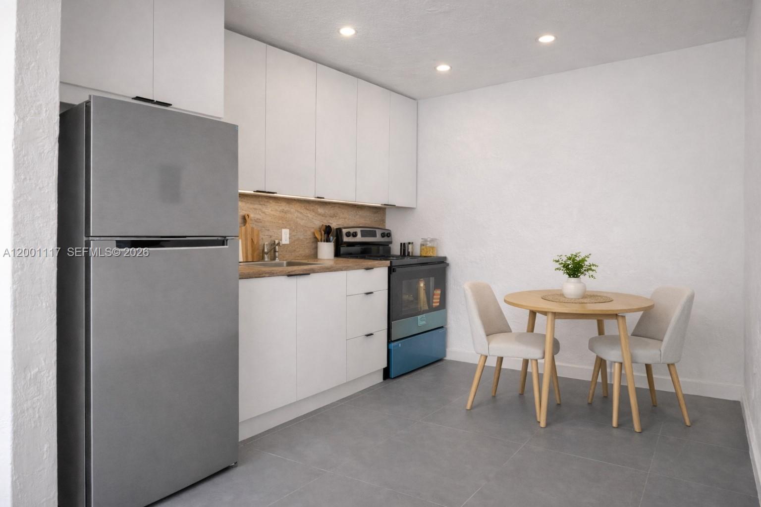 11775 Southwest 223rd Street Miami, FL 33170 - Photo 29 of 42 a white refrigerator freezer sitting in a kitchen with kitchen island and a refrigerator