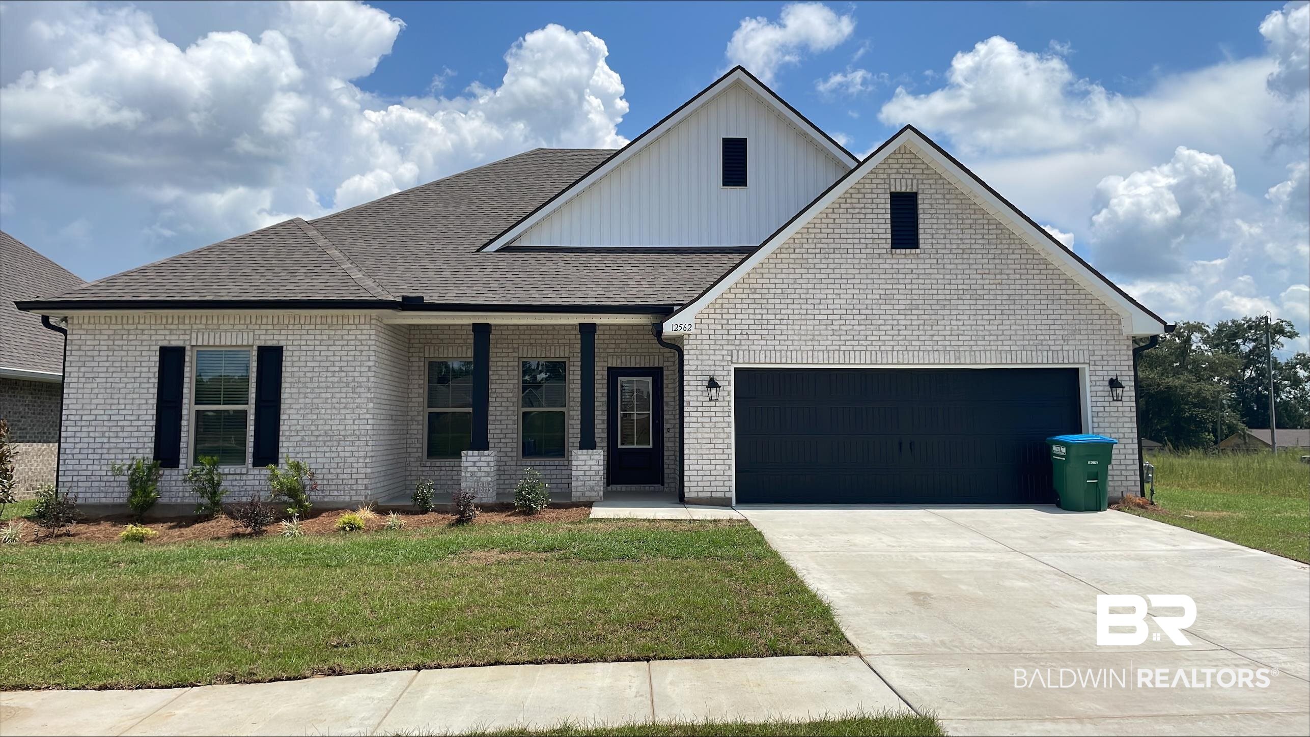 12562 Wagner Avenue Daphne, AL 36527 - Photo 1 of 3 View of front facade with a porch, board and batten siding, a garage, concrete driveway, and a front yard