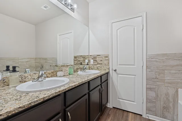 a bathroom with a granite countertop sink and a mirror