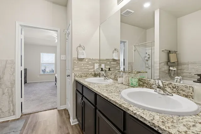 a bathroom with a granite countertop sink and a mirror