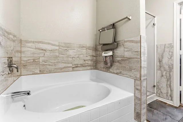 a white bath tub sitting next to a white sink and a shower