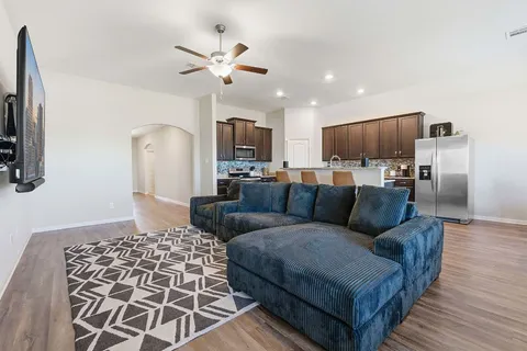 a living room with furniture and a wooden floor