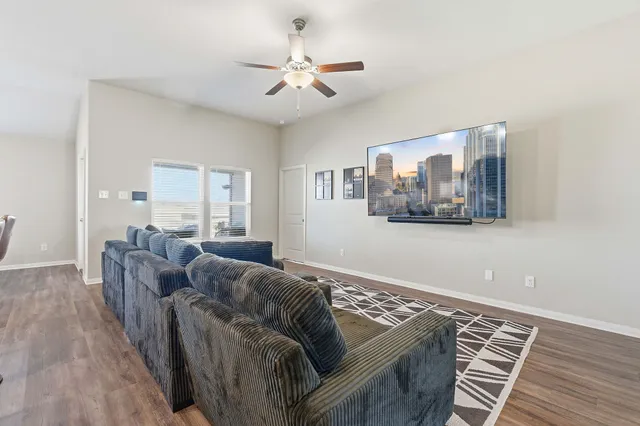 a living room with furniture and a wooden floor