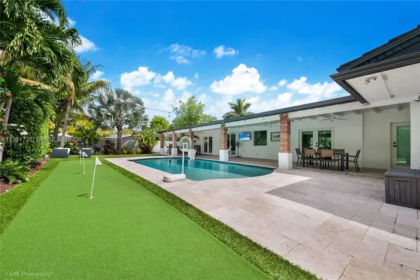 a view of house with swimming pool and porch with furniture