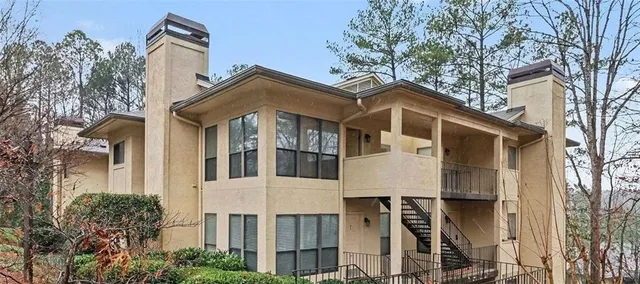a front view of a house with a yard and trees