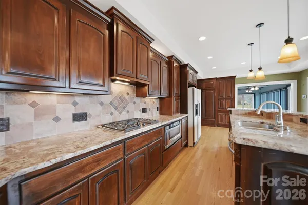 a kitchen with stainless steel appliances granite countertop a sink stove and refrigerator