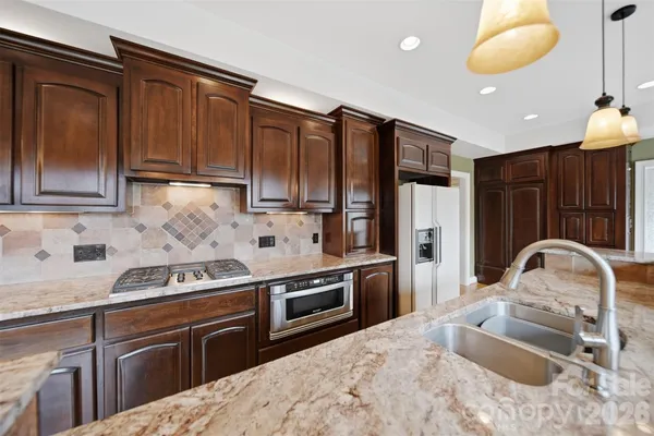 a kitchen with stainless steel appliances granite countertop a sink stove and refrigerator