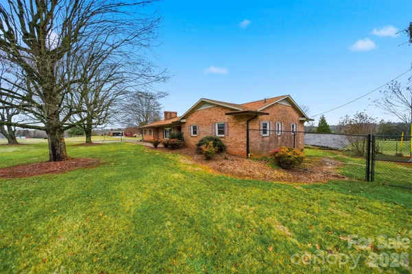 a view of a house with a big yard and large tree