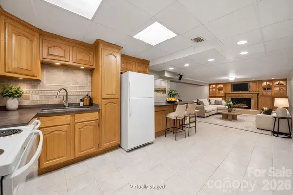 a kitchen with stainless steel appliances granite countertop a refrigerator a stove a sink a dining table and chairs with wooden floor