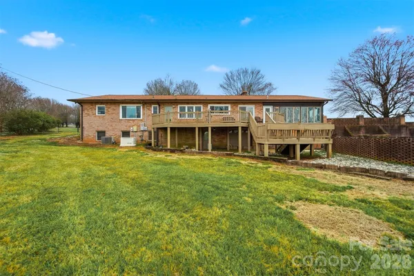 a view of a house with a big yard and large tree
