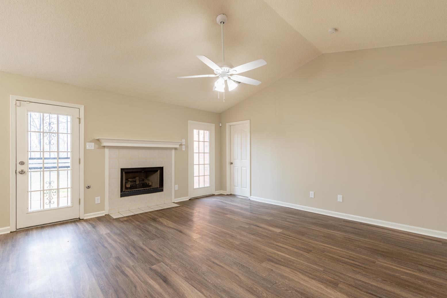 4185 Hampton Manor Lane Memphis, TN 38128 - Photo 10 of 20 an empty room with wooden floor a chandelier fan and windows