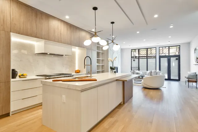 a kitchen with kitchen island a large counter top space a sink stainless steel appliances and cabinets