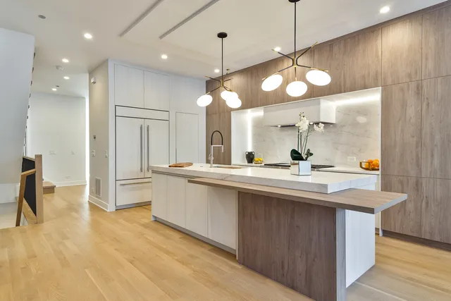 a large kitchen with kitchen island a large island in it