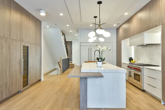 a kitchen with stainless steel appliances granite countertop a sink a stove and a refrigerator