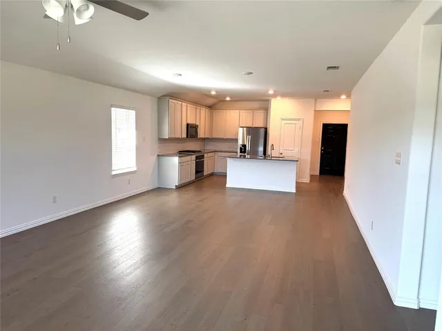 a view of a kitchen with cabinets and wooden floor