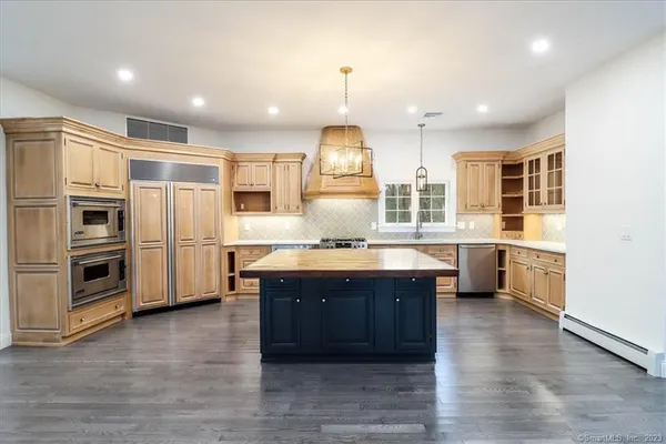 a kitchen with stainless steel appliances granite countertop a sink a stove and a wooden floors