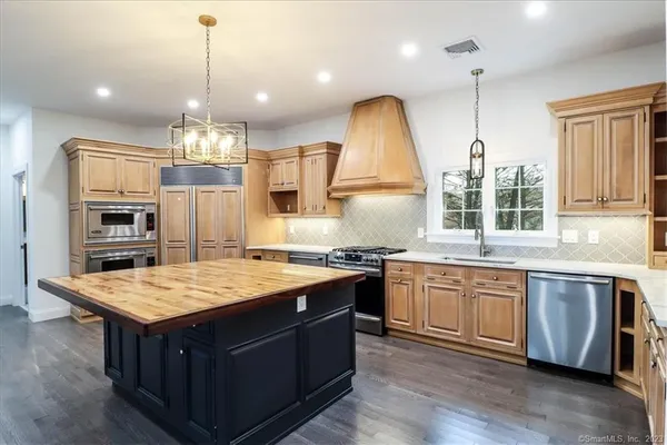 a kitchen with kitchen island granite countertop a sink stove and wooden cabinets