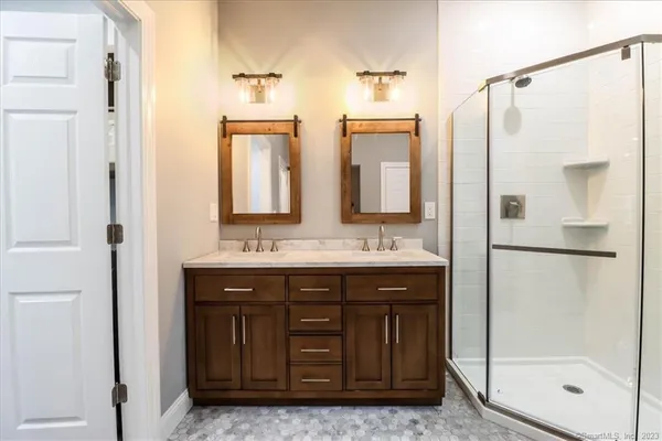 a bathroom with a shower sink and mirror