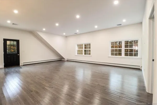 an empty room with wooden floor and windows