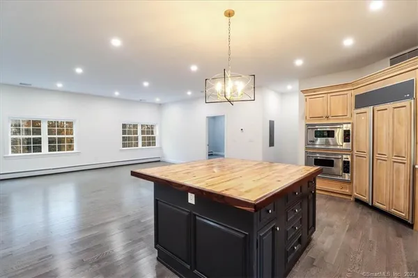 a kitchen with stainless steel appliances granite countertop a sink a oven a stove and a wooden floors