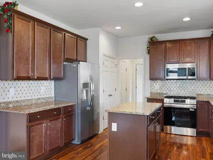 a kitchen with stainless steel appliances granite countertop a refrigerator stove and sink