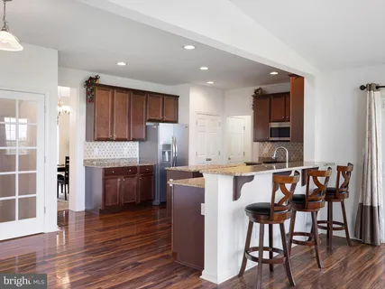 a kitchen with granite countertop wooden floors and stainless steel appliances